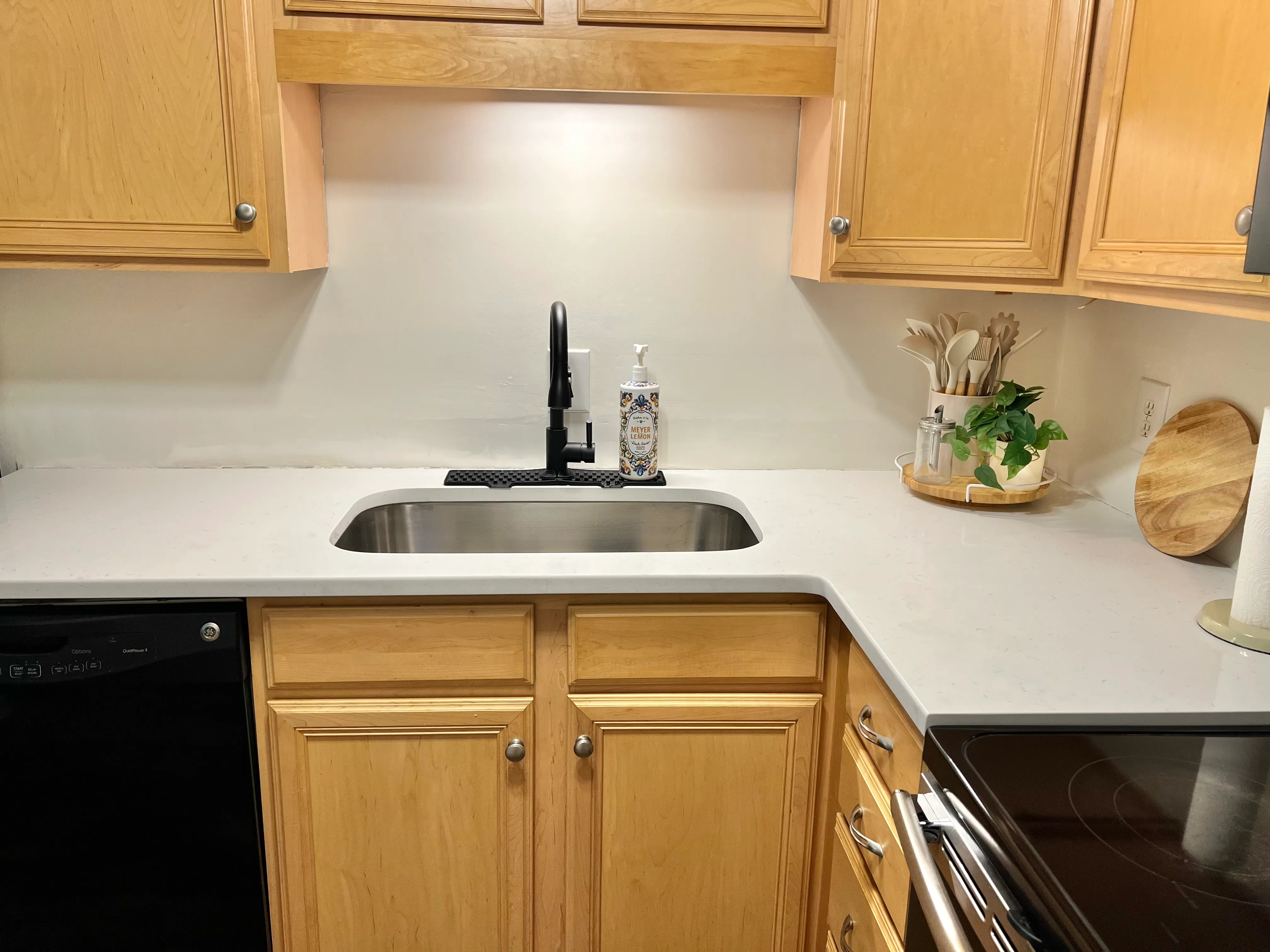 Kitchen counter detail with black faucet and quartz surface