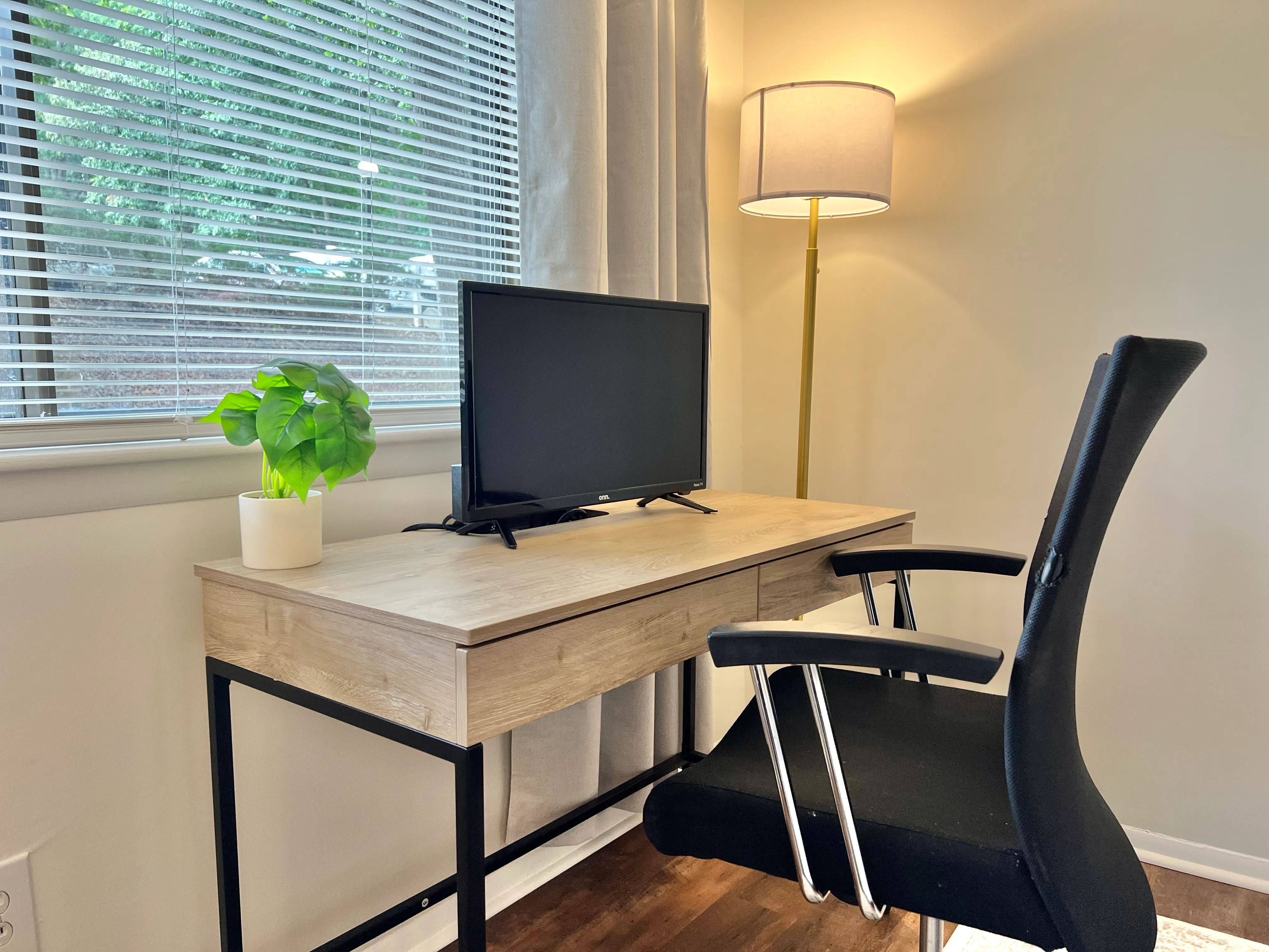 Dedicated workspace with a desk, ergonomic chair, monitor, and window light
